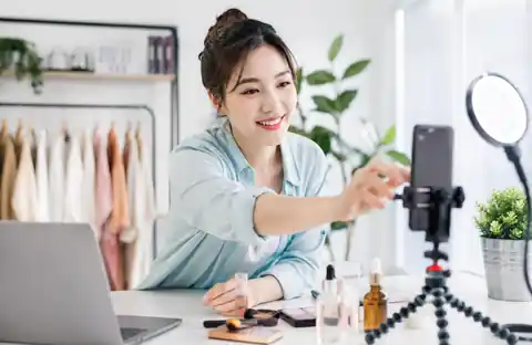 Asian UGC creator preparing a beauty video with a smartphone and ring light