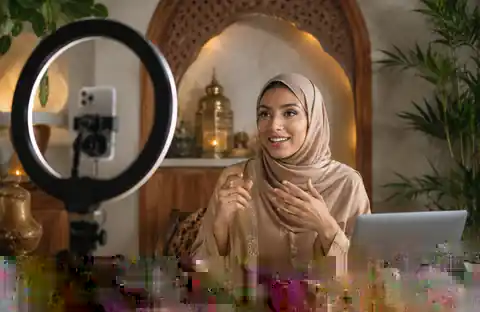 Hijabi UGC creator in local attire recording a beauty livestream with a smartphone